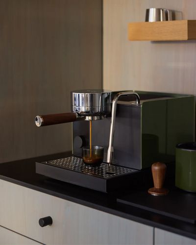 Fellow Espresso series 1 espresso machine brewing espresso in a modern kitchen setting.